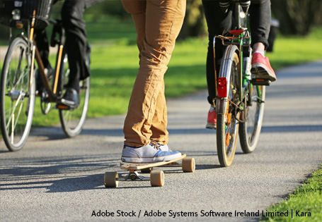 Umweltfreundliche Mobilität Zwei Fahrräder und ein Skateboard auf einem Weg